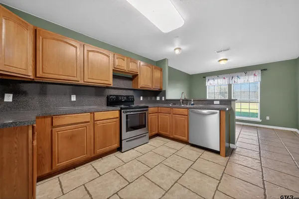 a kitchen with stainless steel appliances granite countertop a stove sink and cabinets