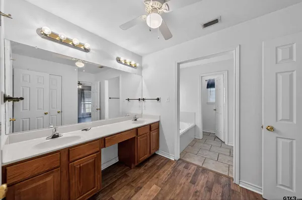 a spacious bathroom with a double vanity sink a large mirror and shower