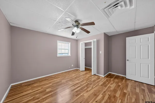 a view of a livingroom with a chandelier fan and wooden floor