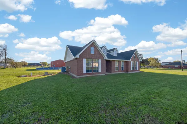 a view of a house next to a big yard with large trees