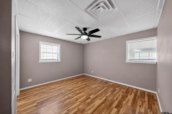 a view of empty room with wooden floor