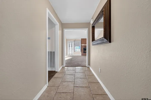 a view of a hallway to a livingroom with furniture