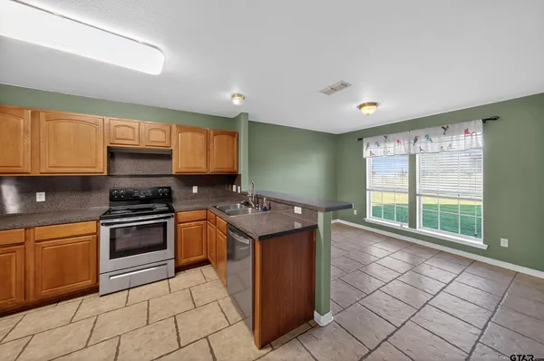 a kitchen with a stove a sink and a refrigerator