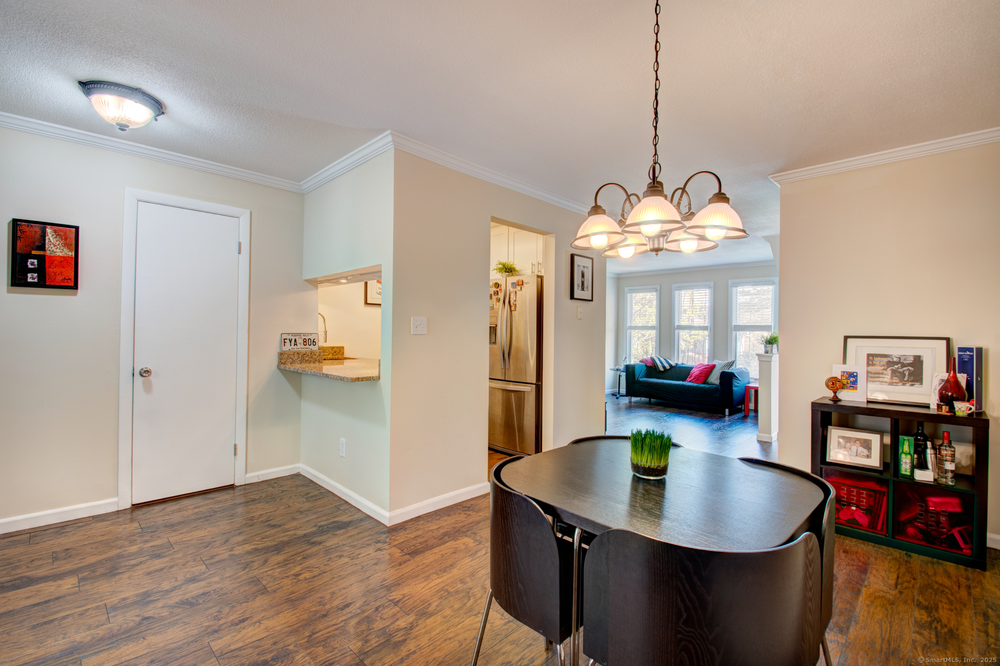 184 Gravel Street, Unit 26 Meriden, CT 06450 - Photo 2 of 27 a dining room with furniture a rug a potted plant and a chandelier