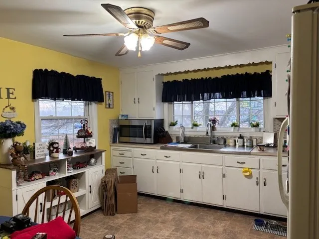 a kitchen with a sink dishwasher a stove a microwave oven and a dining table with wooden floor