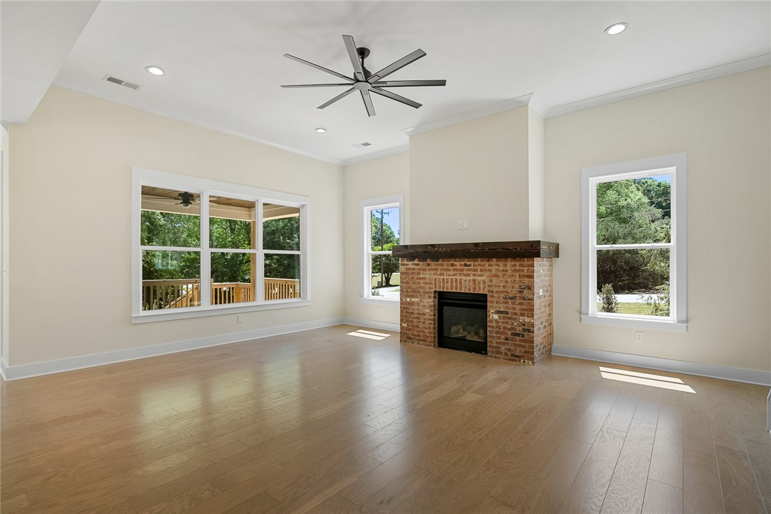 100 Garden Gate Drive Anderson, SC 29621 - Photo 9 of 43 Bright and airy living area featuring a fireplace, ample natural light, and classic hardwood floors.