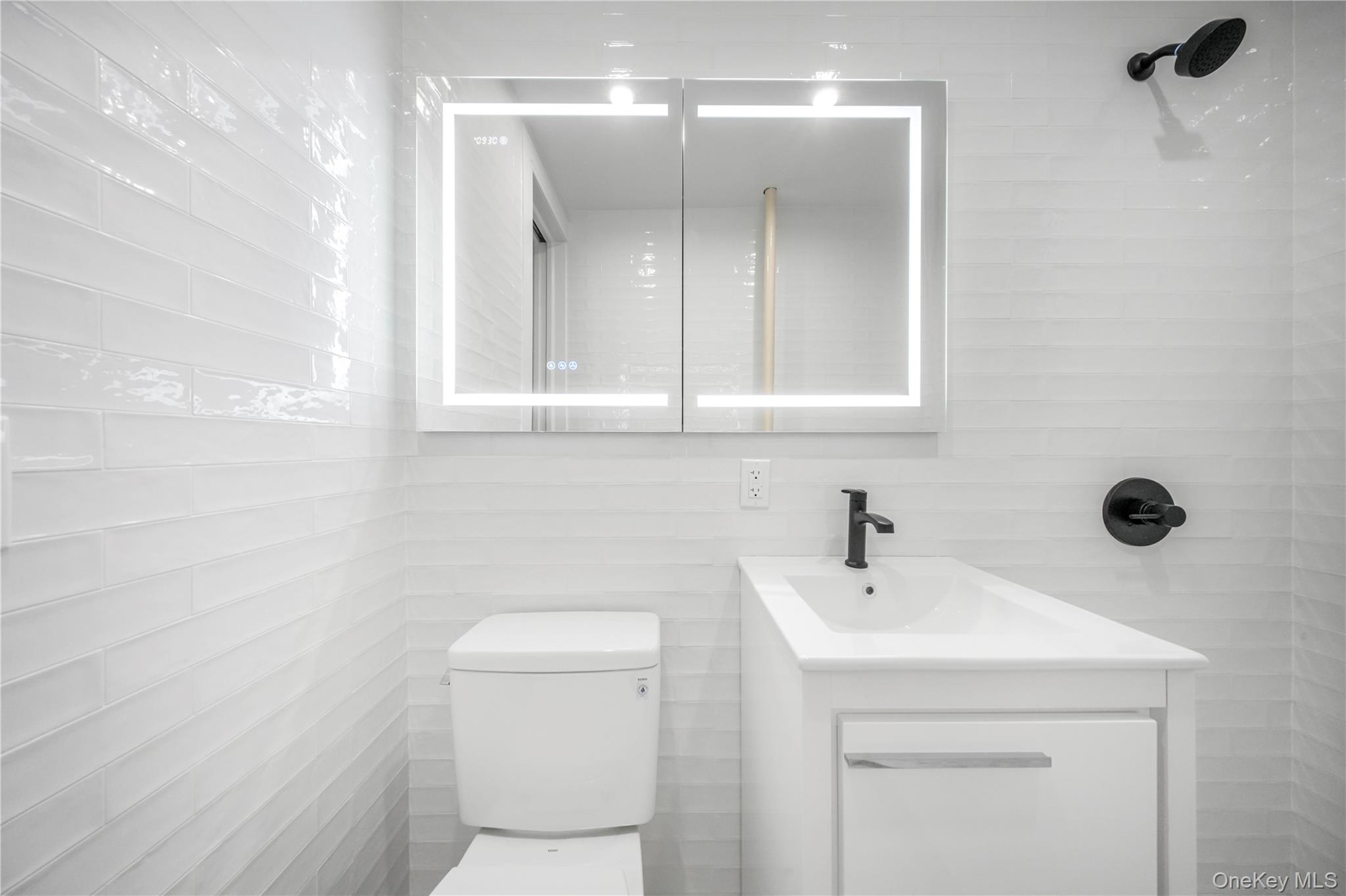 31-14 Crescent Street, Unit 5B Queens, NY 11106 - Photo 6 of 16 Bathroom with vanity and tile walls