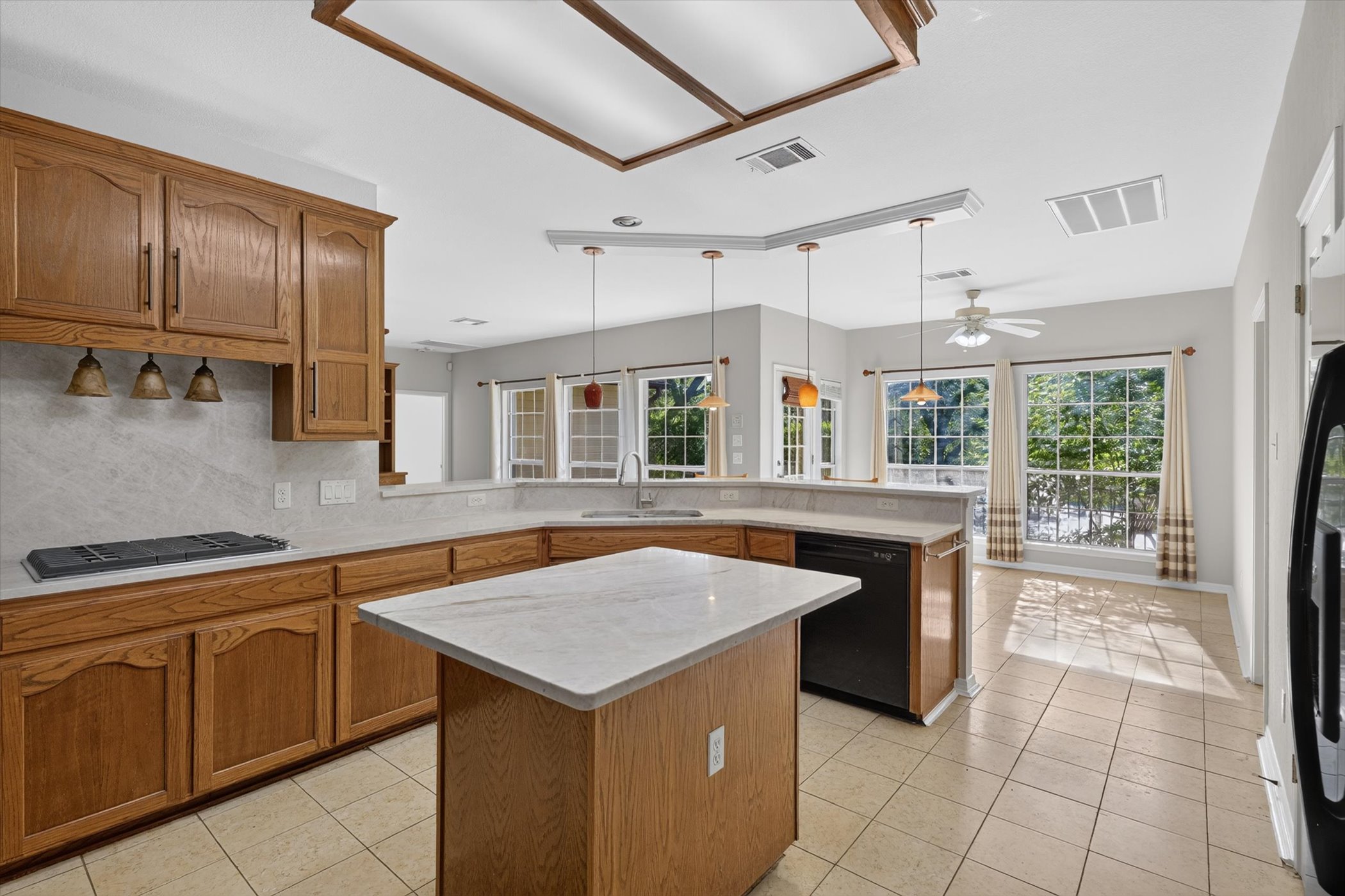 13615 Copperleaf Trail Manchaca, TX 78652 - Photo 16 of 38 An inviting kitchen with a central island and light wood cabinetry, offering abundant counter space and scenic outdoor views.