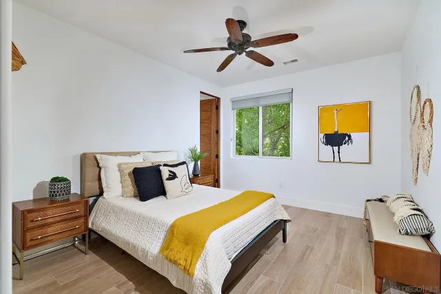 a bedroom with a bed and wooden floor