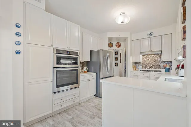 a kitchen with white cabinets and stainless steel appliances