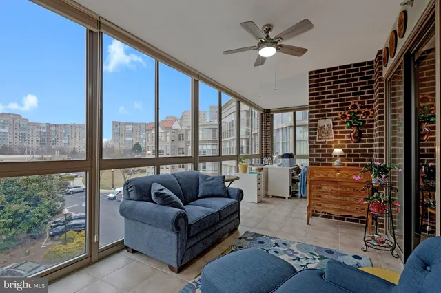 a living room with furniture and a floor to ceiling window