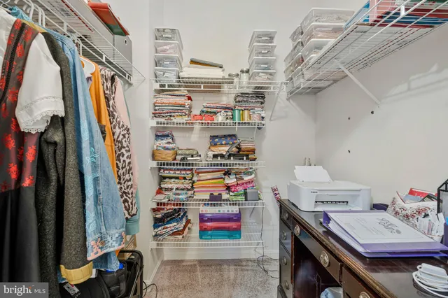 a view of walk in closet with clothes and shoes