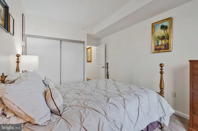 a bedroom with a bed and painting on the wall