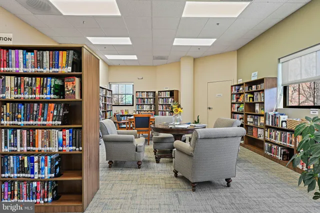 a living room with furniture and a book shelf