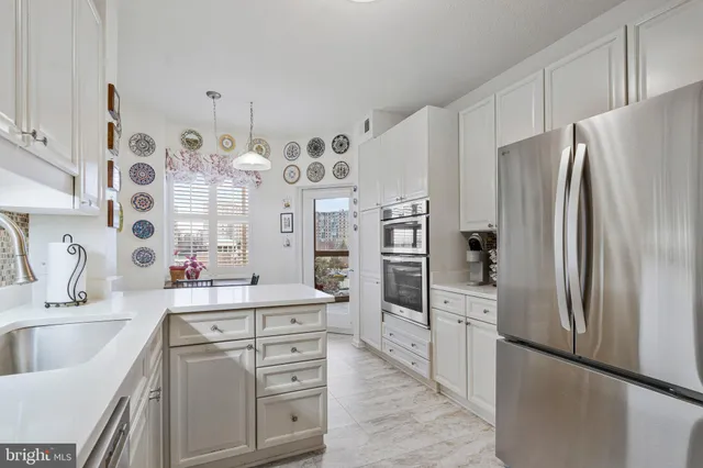 a kitchen with stainless steel appliances a refrigerator sink and cabinets