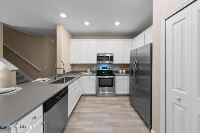 a kitchen with stainless steel appliances granite countertop a refrigerator and a sink