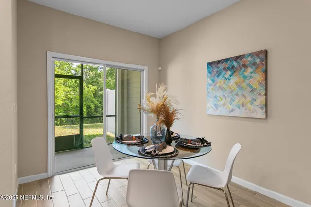 a kitchen with stainless steel appliances kitchen island granite countertop a table chairs stove and refrigerator