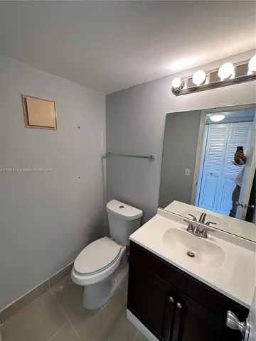 a bathroom with a toilet a sink and mirror