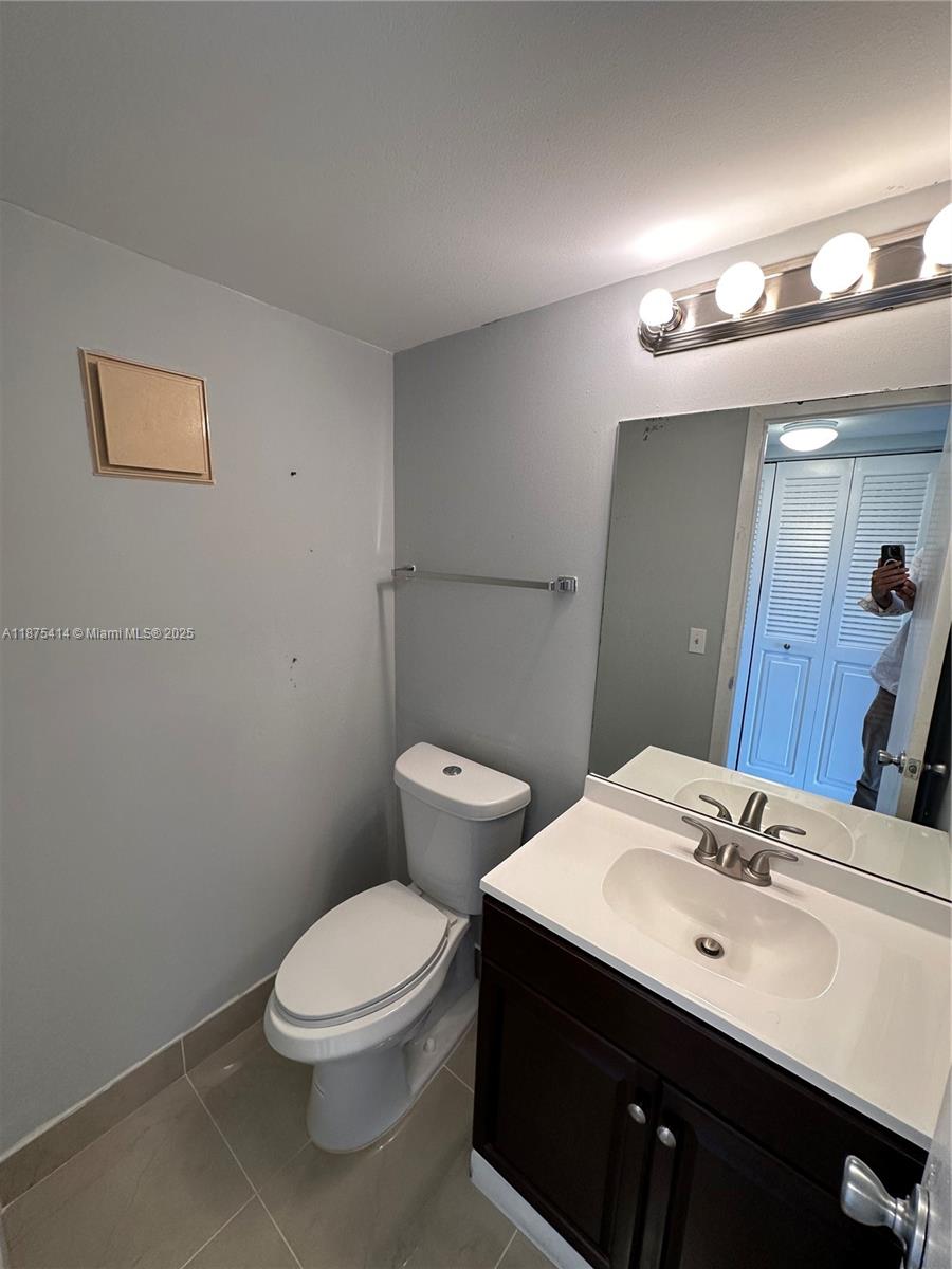 37 Brighton A, Unit 37 Boca Raton, FL 33434 - Photo 12 of 30 a bathroom with a toilet a sink and mirror