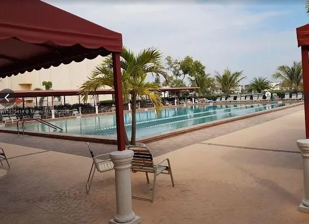 a view of a swimming pool with a patio and a yard