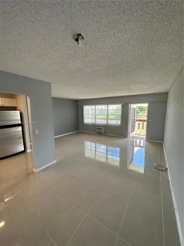 an empty room with floor to ceiling window and dining room