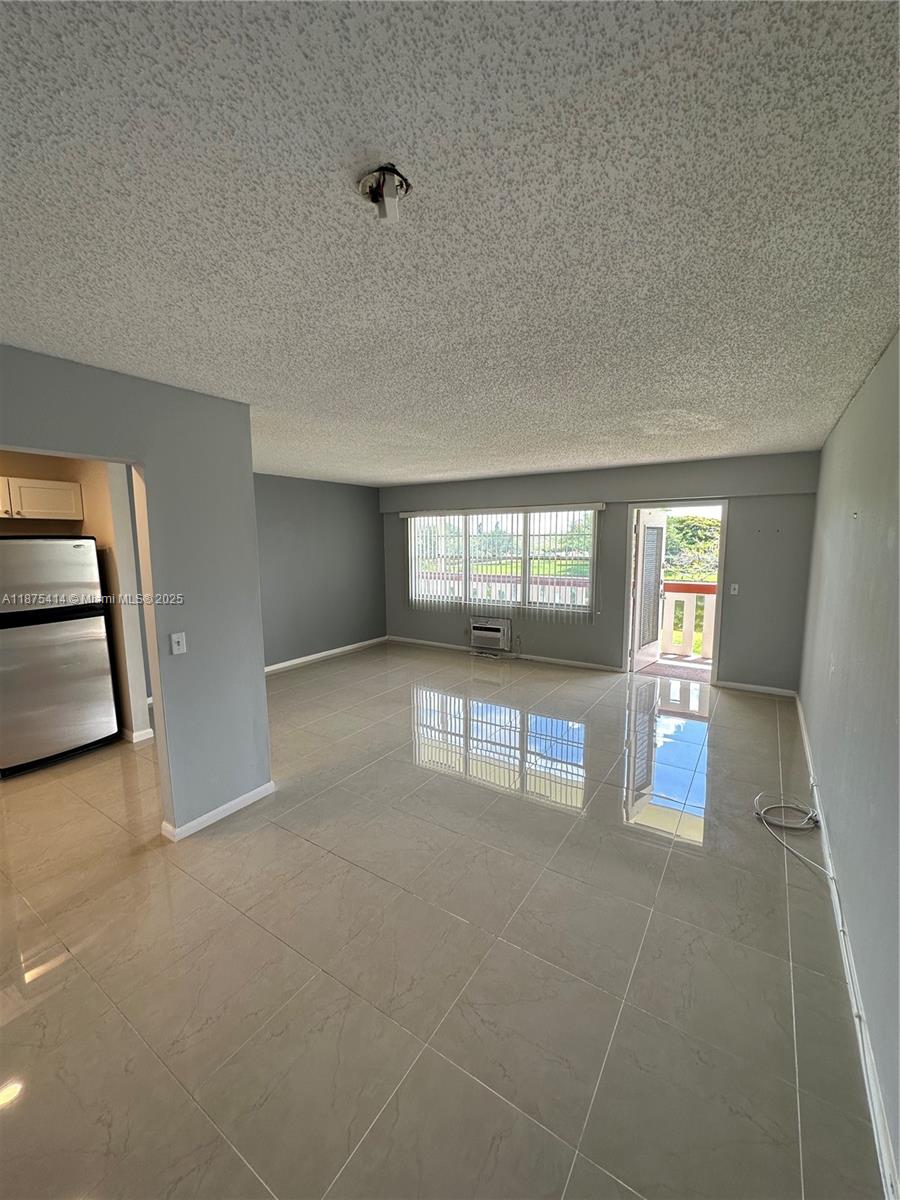 37 Brighton A, Unit 37 Boca Raton, FL 33434 - Photo 4 of 30 an empty room with floor to ceiling window and dining room