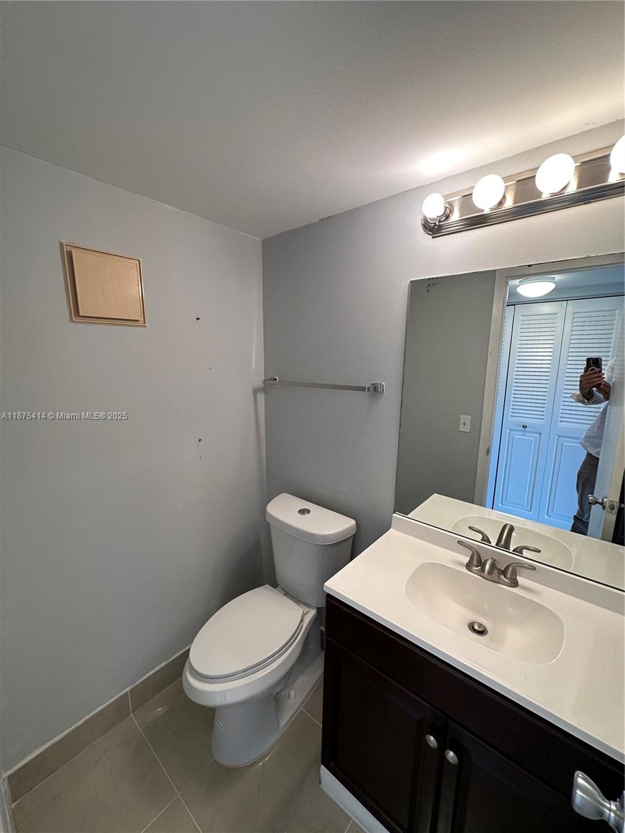 37 Brighton A, Unit 37 Boca Raton, FL 33434 - Photo 5 of 30 a bathroom with a toilet a sink and mirror