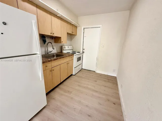 a kitchen with stainless steel appliances a refrigerator sink and cabinets