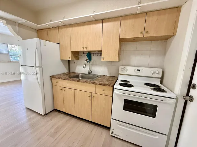 a kitchen with a white stove top oven and refrigerator