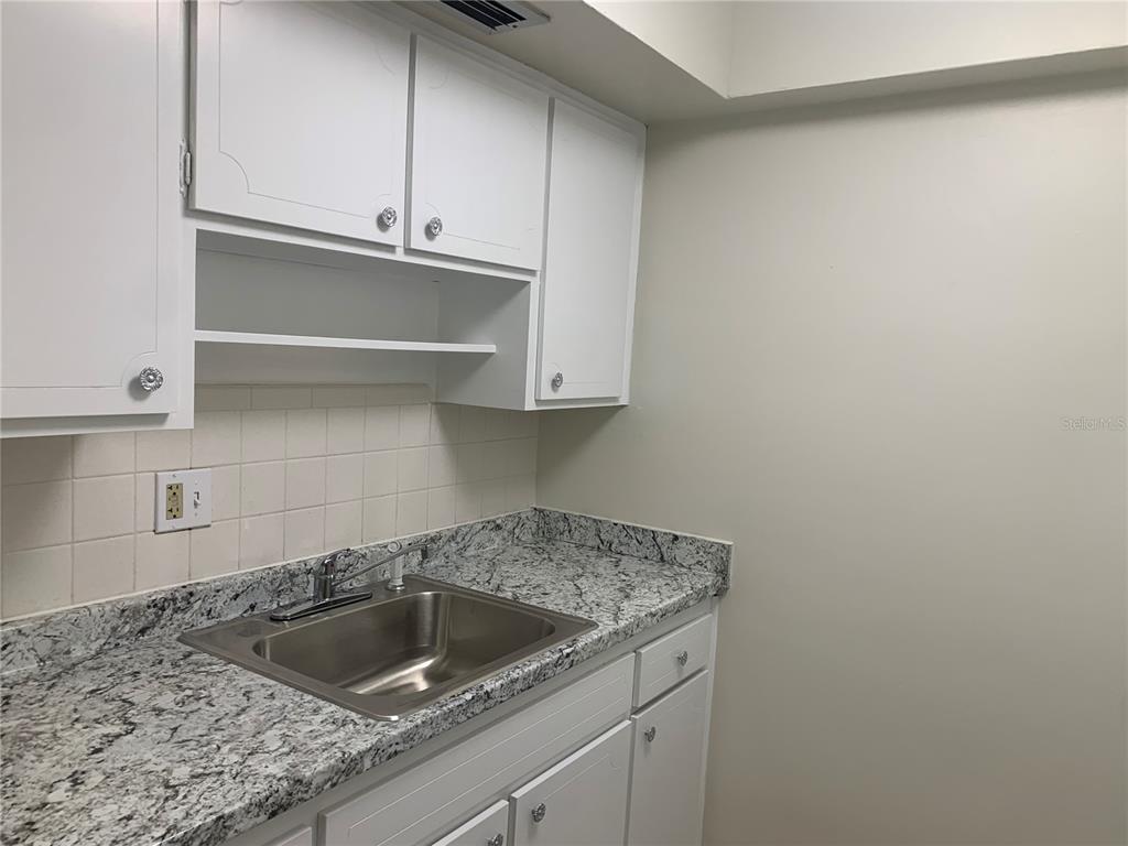 1257 Drew Street, Unit 15 Clearwater, FL 33755 - Photo 11 of 30 a kitchen with a sink and cabinets