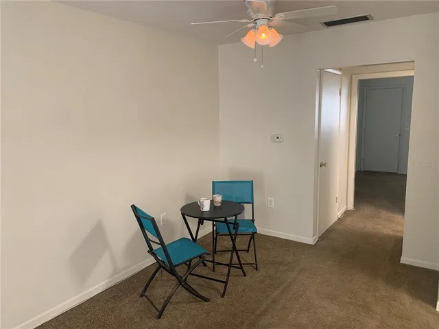 a view of a dining room with furniture and chandelier fan