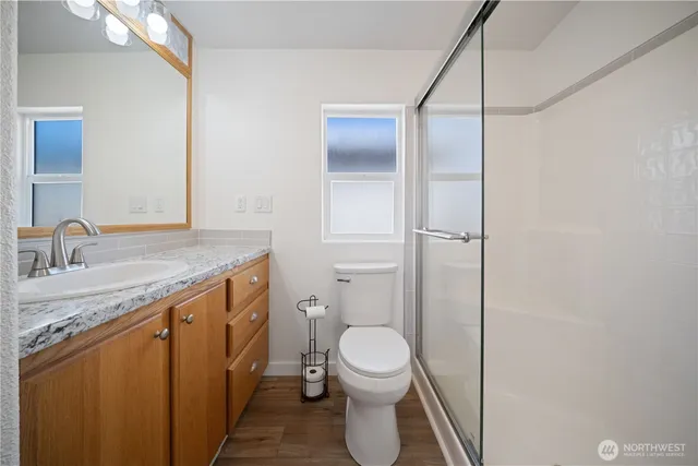 a bathroom with a granite countertop sink toilet and shower