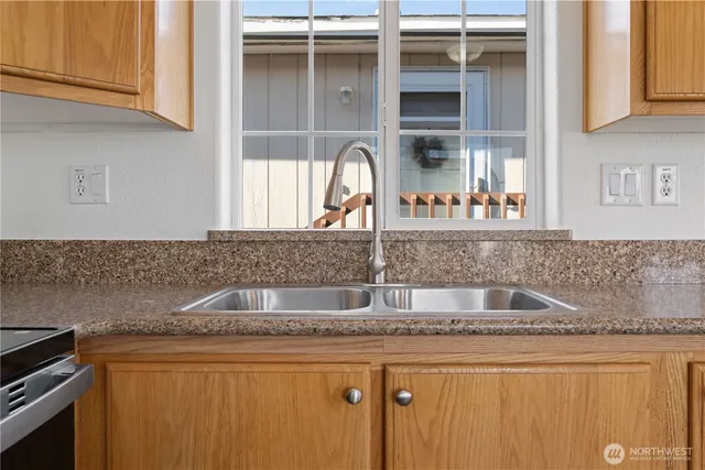 a kitchen with granite countertop a sink and cabinets