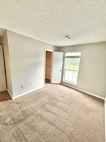 an empty room with windows and closet