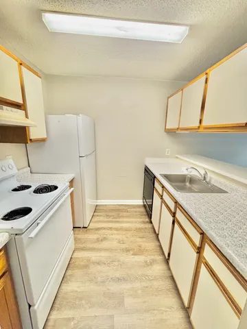 a view of a kitchen with a sink and a stove top oven