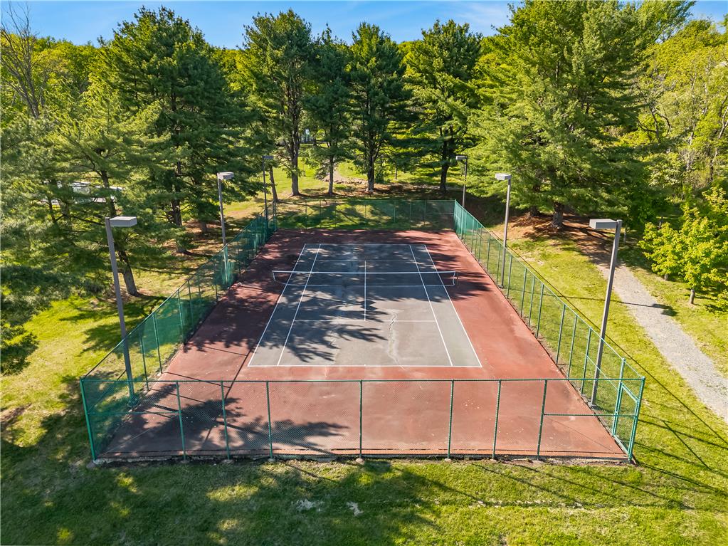 1506 Pleasant View Road Coopersburg, PA 18036 - Photo 94 of 97 An outdoor tennis court awaits, bordered by a vibrant green fence and towering shade trees.