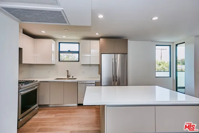 a kitchen with a sink a refrigerator and a stove