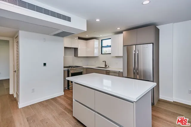 a kitchen with stainless steel appliances a refrigerator sink and microwave