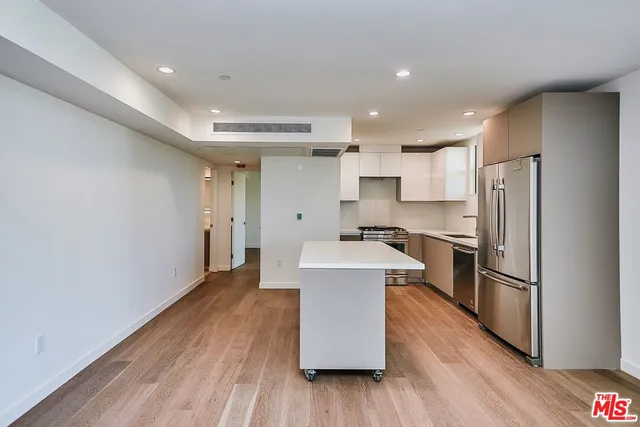 a kitchen with refrigerator and white cabinets