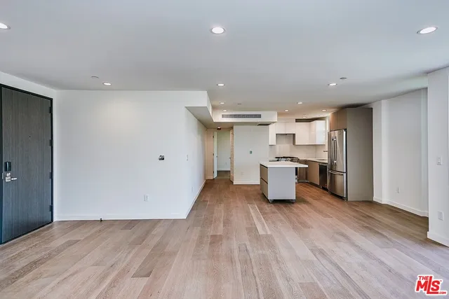 a kitchen with stainless steel appliances a refrigerator sink and white cabinets