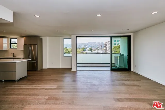 wooden floor in an empty room with a kitchen