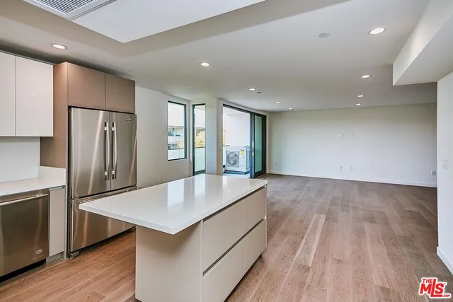 a large kitchen with stainless steel appliances granite countertop a refrigerator and a sink