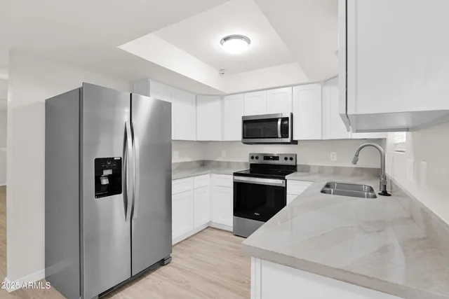 a kitchen with granite countertop a refrigerator and a sink