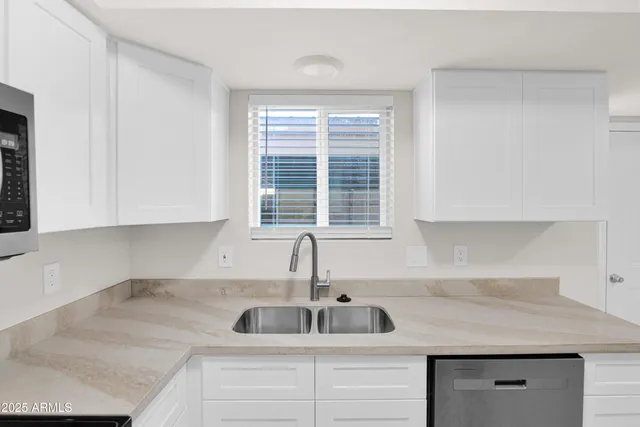 a kitchen with a sink cabinets and window