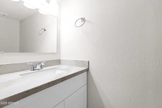 a bathroom with a sink vanity and a mirror