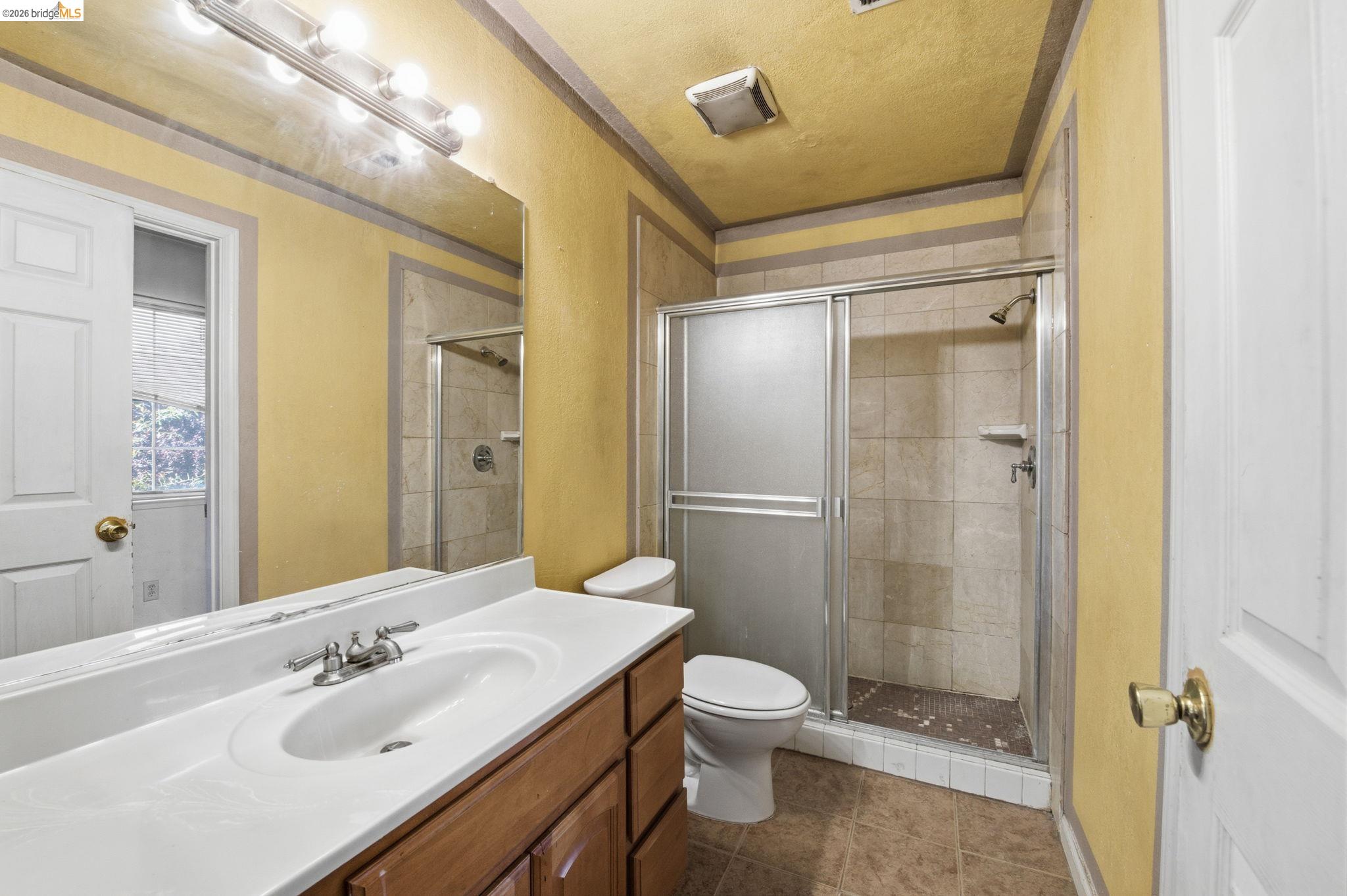 1496 Adeline Street Oakland, CA 94607 - Photo 12 of 17 a bathroom with a sink mirror toilet and shower