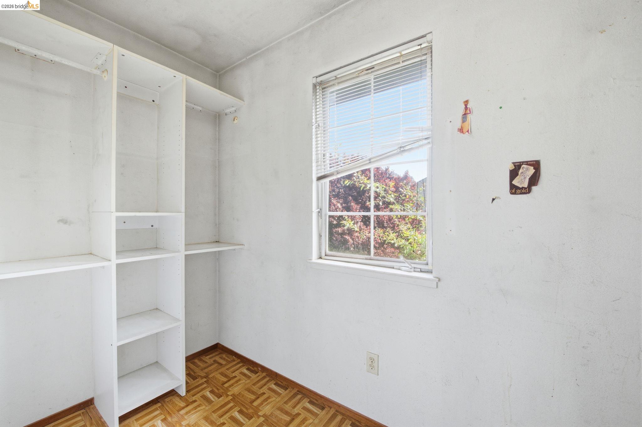 1496 Adeline Street Oakland, CA 94607 - Photo 13 of 17 a view of an empty room with a window and wooden floor
