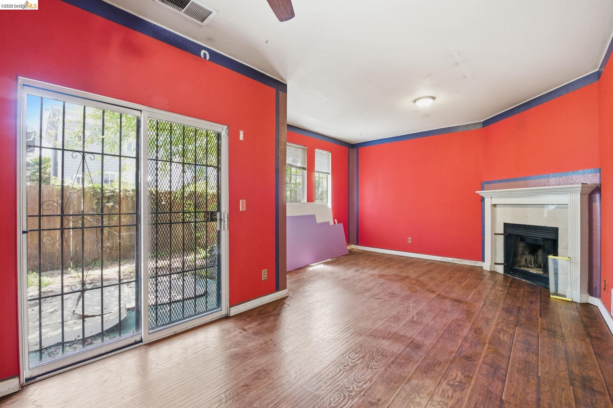 1496 Adeline Street Oakland, CA 94607 - Photo 4 of 17 a view of empty room with wooden floor and fireplace