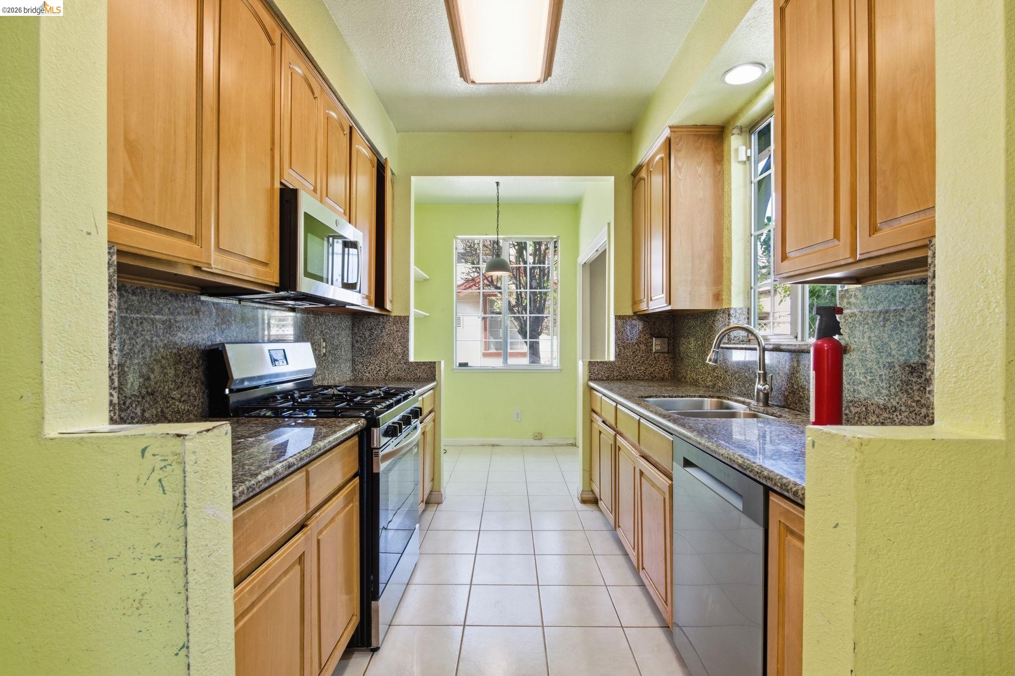 1496 Adeline Street Oakland, CA 94607 - Photo 5 of 17 a kitchen with stainless steel appliances granite countertop a stove a sink and a microwave