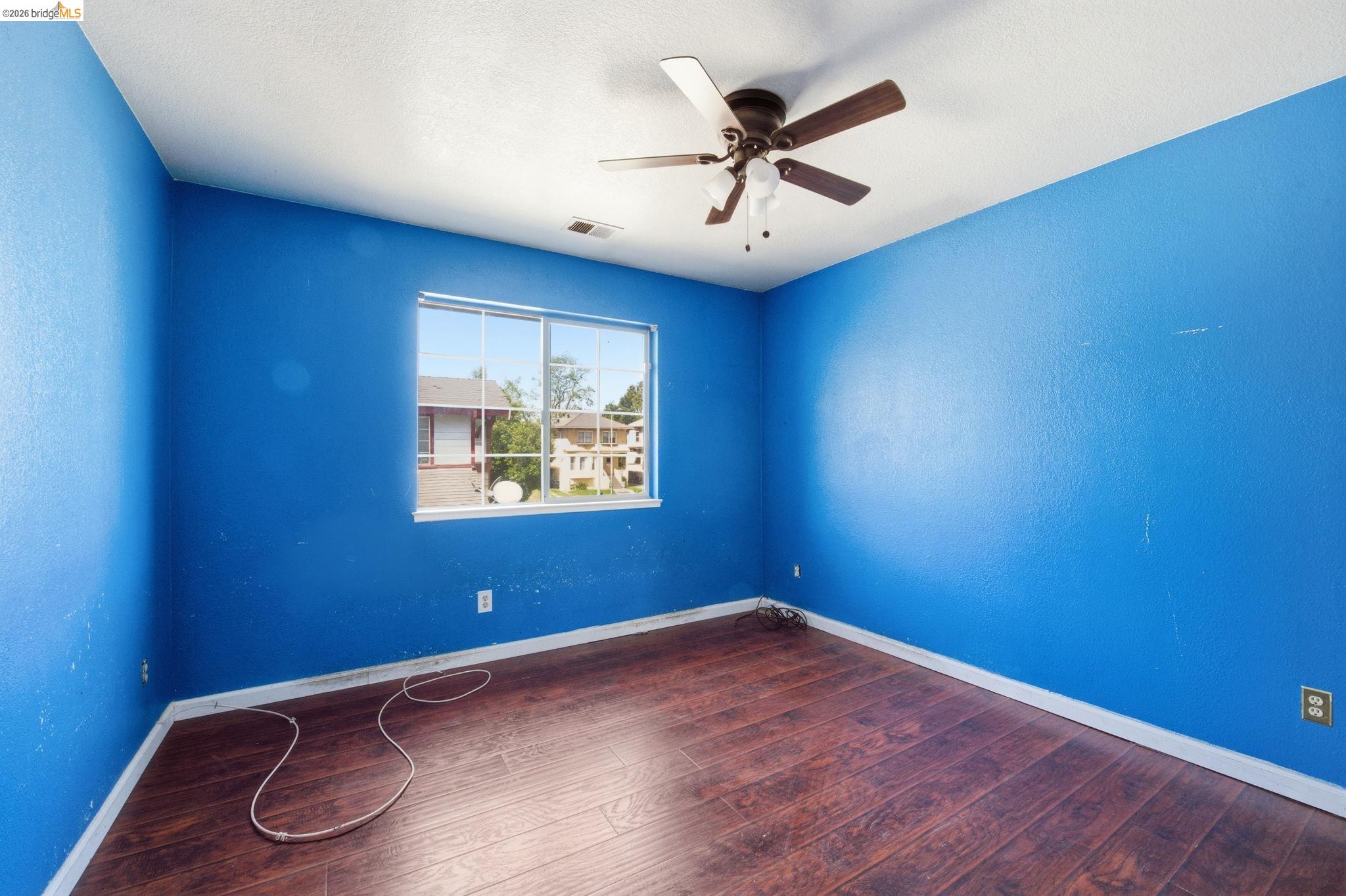 1496 Adeline Street Oakland, CA 94607 - Photo 8 of 17 an empty room with wooden floor and ceiling fan